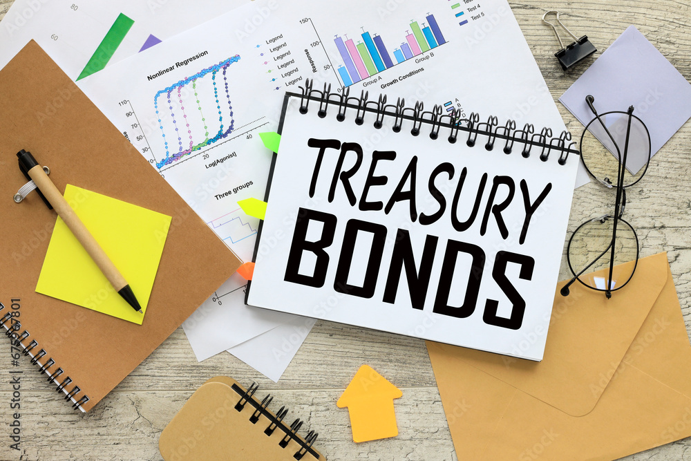 Poster treasury bonds stationery scattered around. a notepad with text in the middle of the table.