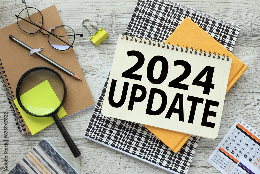 Poster 2024 update text on the page on a bright notebook. glasses and magnifying glass on a craft notebook