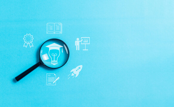 Magnifying glass focus to online education concept on blue background, E-learning education, internet lessons and online webinar.