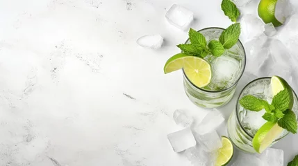 Fototapeten Mojito cocktail alcohol bar long drink traditional Cuba fresh tropical beverage top view copy space two highball glass, with rum, spearmint, lime juice, soda water and ice on white concrete table. © HN Works