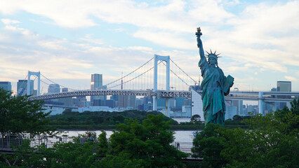 Rainbow Bridge and Statue of Liberty in Odaiba, Tokyo, Japan.