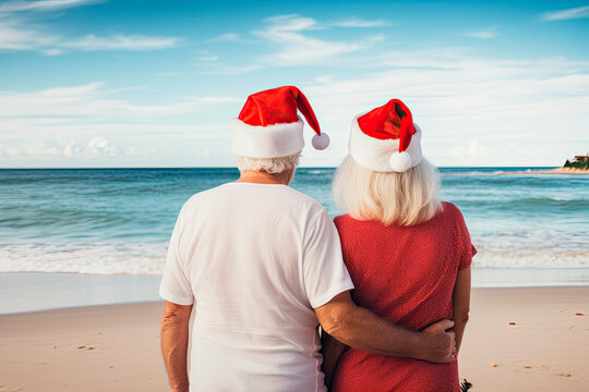 old couple walking on the beach with santa hats. christmas vacation on the beach