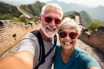 Foto op Plexiglas A happy elderly tourist couple take a selfie in China with the Great Wall in the background. Travel retirement concept. AI generated. © serperm73