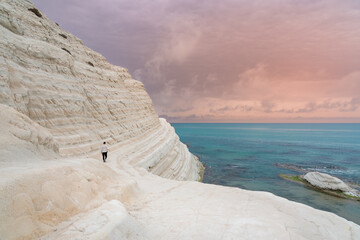 Young man admiring the white limestone cliffs of the Scala dei Turchi, Agrigento, Sicily, Italy, 