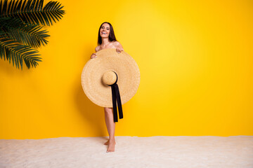 Full length photo of adorable positive lady wear bikini cover body big sun hat empty space isolated yellow color background
