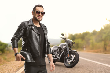 Fototapeta na wymiar Young man on the road in a leather jacket