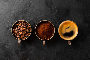 Three different states of coffee - a cup of black coffee, coffee beans and ground coffee on a black background