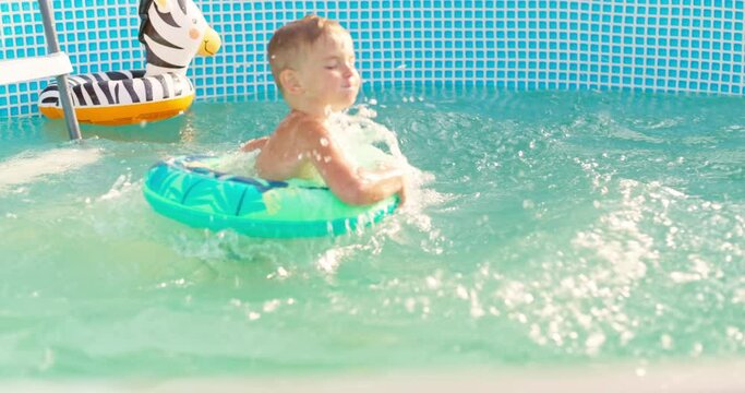Joyful boy jumping into the pool in the backyard enjoying his summer vacation