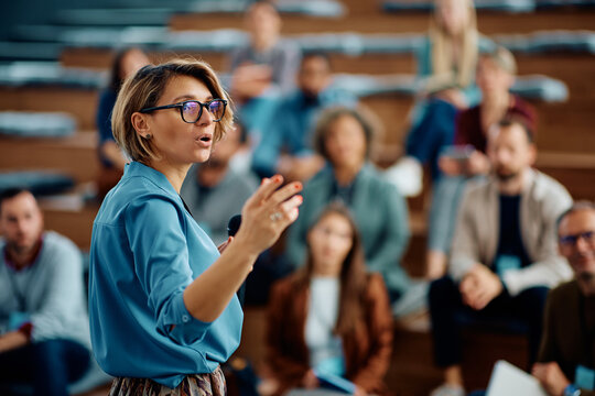 Female speaker giving presentation during business seminar at convention center.