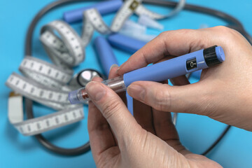 Female hands holding Insulin injection pen  for diabetics.