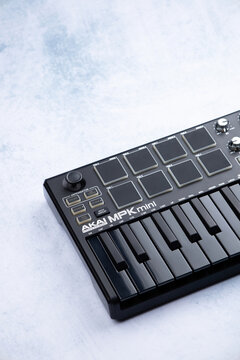 Akai mpk mini mk2 black on a blue and white background.  Close up