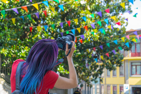 Tourist Woman photographing San Juan festival flags decorations on Porto street
