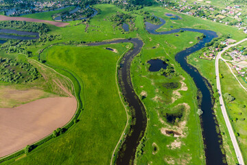 Fototapeta na wymiar Landscape from the air, an elongated and winding river bed among green fields. Old lake Ogublyanka, Kaluga region