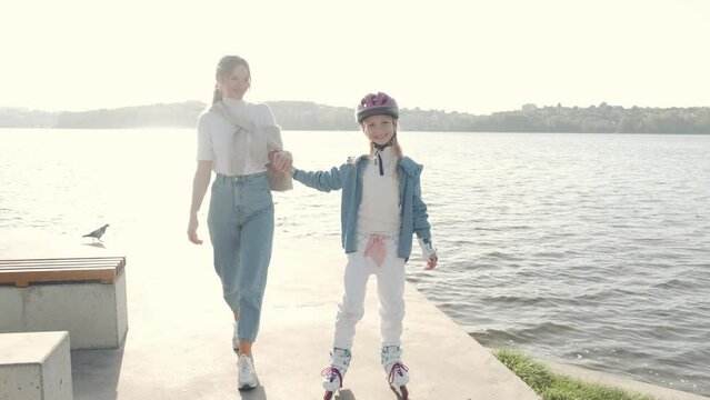 Mon helping her daughter in the park rollerblading enjoying there time togeather
