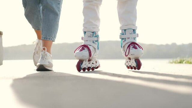 Mon helping her daughter in the park rollerblading enjoying there time togeather