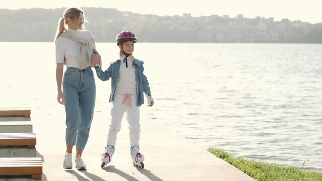 Mon helping her daughter in the park rollerblading enjoying there time togeather