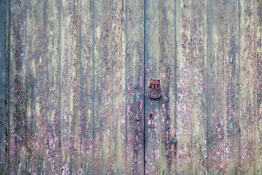 Velho port&atilde;o de madeira com muitas camadas descascadas de tinta de v&aacute;rias cores. Imagem de fundo.