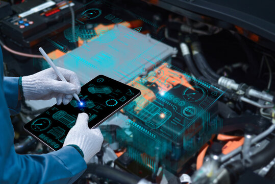 Auto mechanic using a tablet wireless scanning tool to check the ECU engine system; automobile information displayed on a screen; mechanic working on cars at a garage