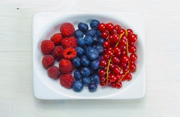 mix of raspberries, blueberries, and currants graces the rectangular container.