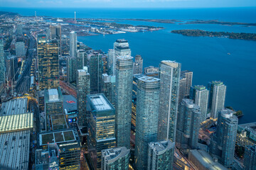 The view of downtown Toronto skyline skyscrapers from the top of CN tower. Lake at dawn, city light bright night long exposure aerial above view