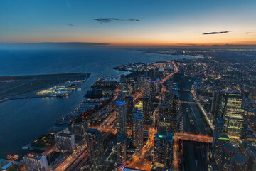 The view of downtown Toronto skyline skyscrapers from the top of CN tower. Lake at dawn, city light...