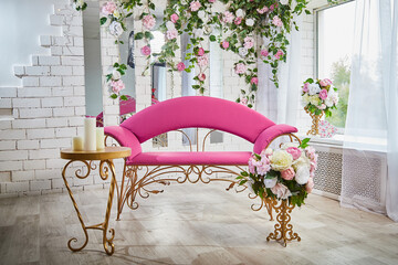 Beautiful interior with a red armchair, couch or sofa and flowers on the front and background. A...