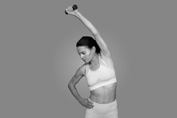 fit woman using a hand weight dumbell, close up, black and white.