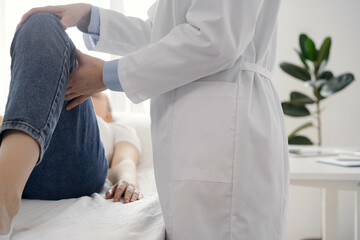 Doctor and patient are at the usual medical inspection in the clinic. Therapist examines a young woman's knee. Medicine concept