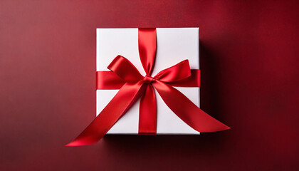 Top view of white present box tied with red ribbon