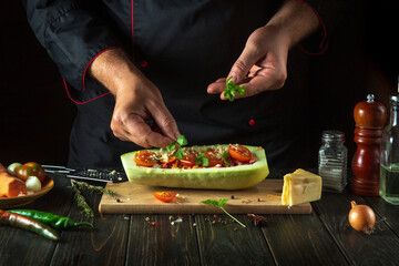 The chef adds green parsley to the zucchini. The concept of cooking a national stuffed squash boat or marrow in a restaurant kitchen. Free space for menu or recipe
