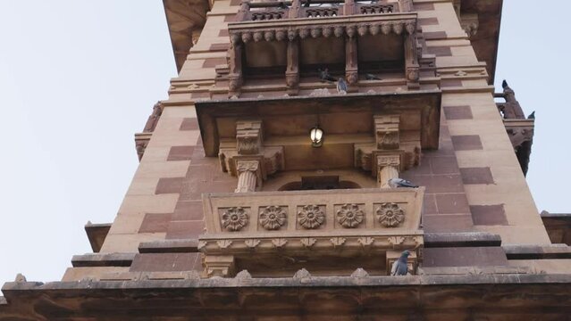 red stone clock tower unique architecture at day from different angle