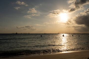 Beautiful sunset on the sea surrounded by clouds and the silhouette of boats in Isla Mujeres.