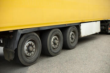 Wheels of truck. Large trailer wheels. Yellow truck trailer.