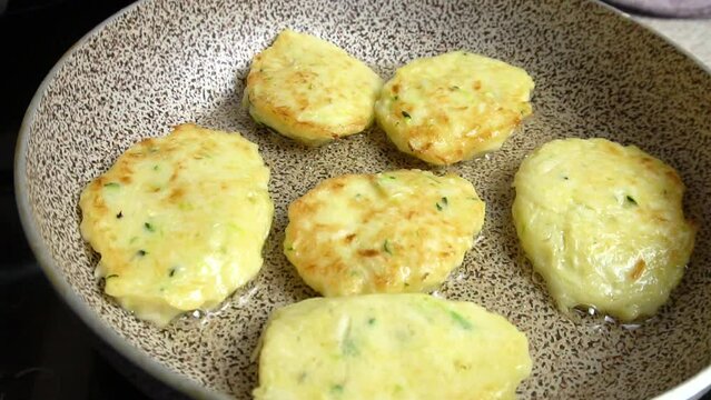 
Description: Frying zucchini pancakes in boiling oil in a frying pan. A simple homemade dish. Cooking master class. Video recipe. 
