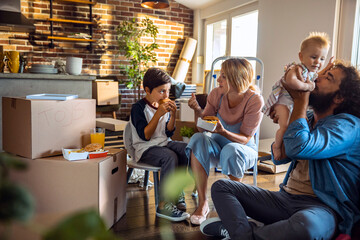 Family Moving Day: Enjoying a Meal Break Amidst Packed Boxes