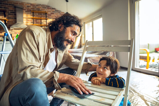 Father and Son restoring wooden chair at home