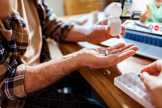 Close up senior man organizing medication at home