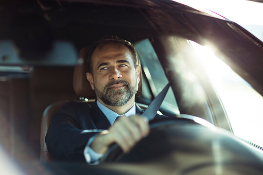 Focused businessman drives his car in the morning light