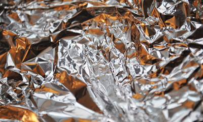 Silver foil background with light reflections. Silver textured wall.