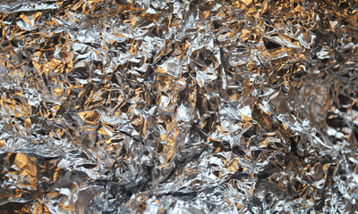 Silver foil background with light reflections. Silver textured wall.