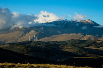 Wind farm with turbines on the mountains. Eco-sustainable industry with nature-friendly...
