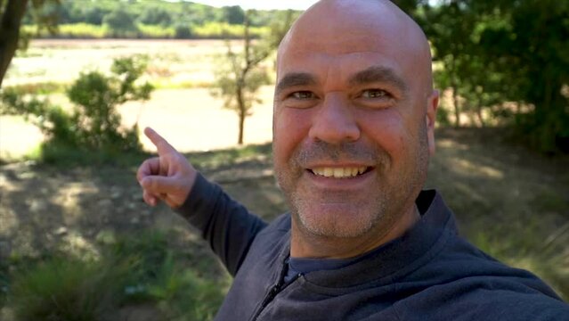 Slow motion, happy man takes a video selfie in the forest.