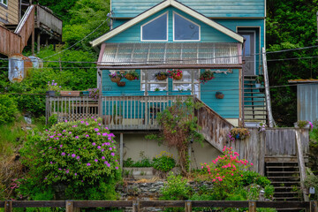 Street city view with wooden houses, shops, cars and mountain wilderness nature in Ketchikan,...
