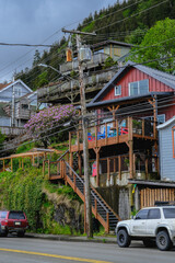 Fototapeta premium Street city view with wooden houses, shops, cars and mountain wilderness nature in Ketchikan, Alaska, popular cruise destination for whale watching in wildlife tours