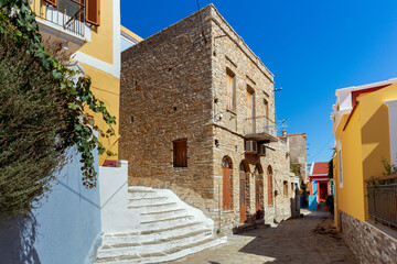 Colorful traditional multi-colored houses on a narrow street of Symi island.