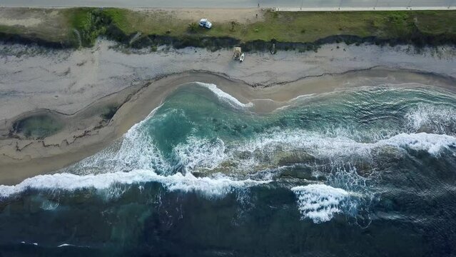 Plan large vue a&eacute;rienne en top-shot d'une plage avec un van am&eacute;nag&eacute;, et un bateau sur la plage