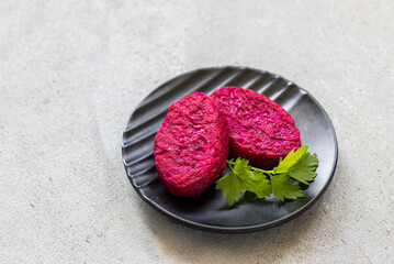 Beetroot cutlets with parsley, on a plate. Light grey background