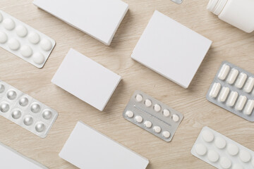 Flat lay with different pills in blister packaging and boxes and on wooden background - obrazy, fototapety, plakaty