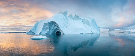 Towering great icebergs and their reflections in the Ilulissat Icefjord in Greenland