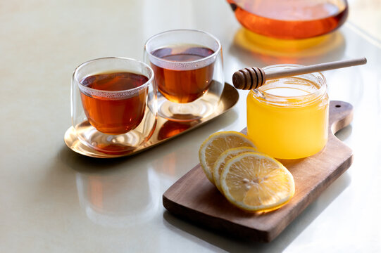 Healing warm tea with honey and lemon at home table